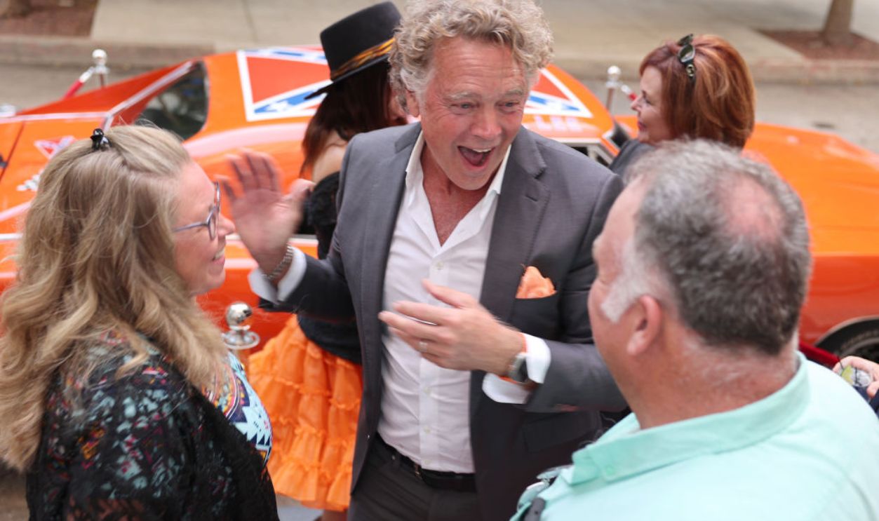 BATON ROUGE, LOUISIANA - AUGUST 14: John Schneider speak with a couple of visitors during a marriage celebration at the Watermark Hotel on August 14, 2024 in Baton Rouge, Louisiana. 