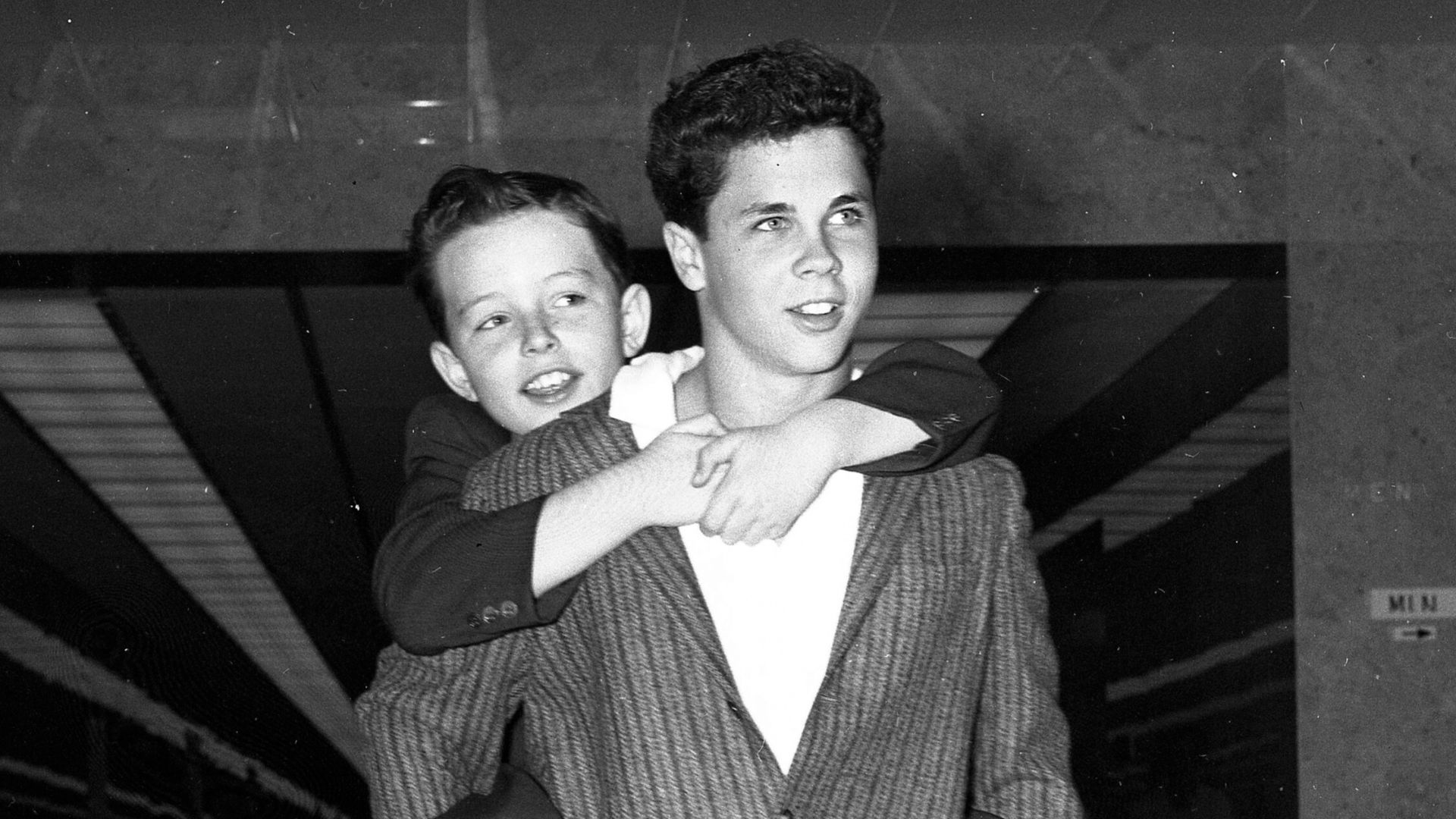 SAVING MONEY—Jerry Mathers, 10, better known as Little Beaver, rides out of courtroom on the back of his TV show brother, Tony Dow, 13, after they had discussed their savings plans with the judge.