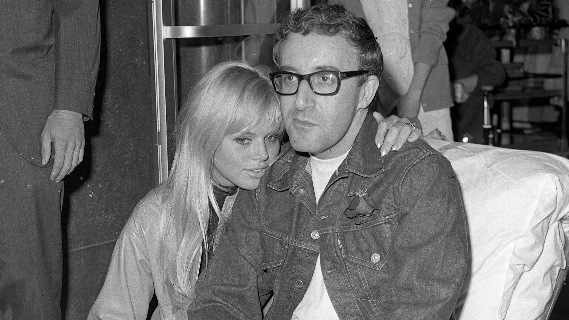 GOING HOME—British comedian Peter Sellers, 38, stricken with a heart attack April 6 that almost cost him his life, gets a hug from his Swedish actress wife, Britt Ekland, 21, as he leaves Cedars of Lebanon Hospital on an ambulance litter