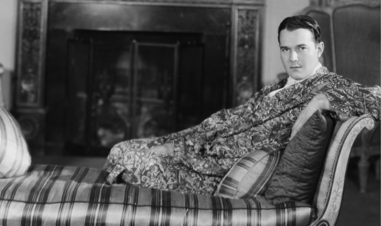 American actor and interior designer William Haines (1900 - 1973) on a chaise longue at his home, circa 1928.