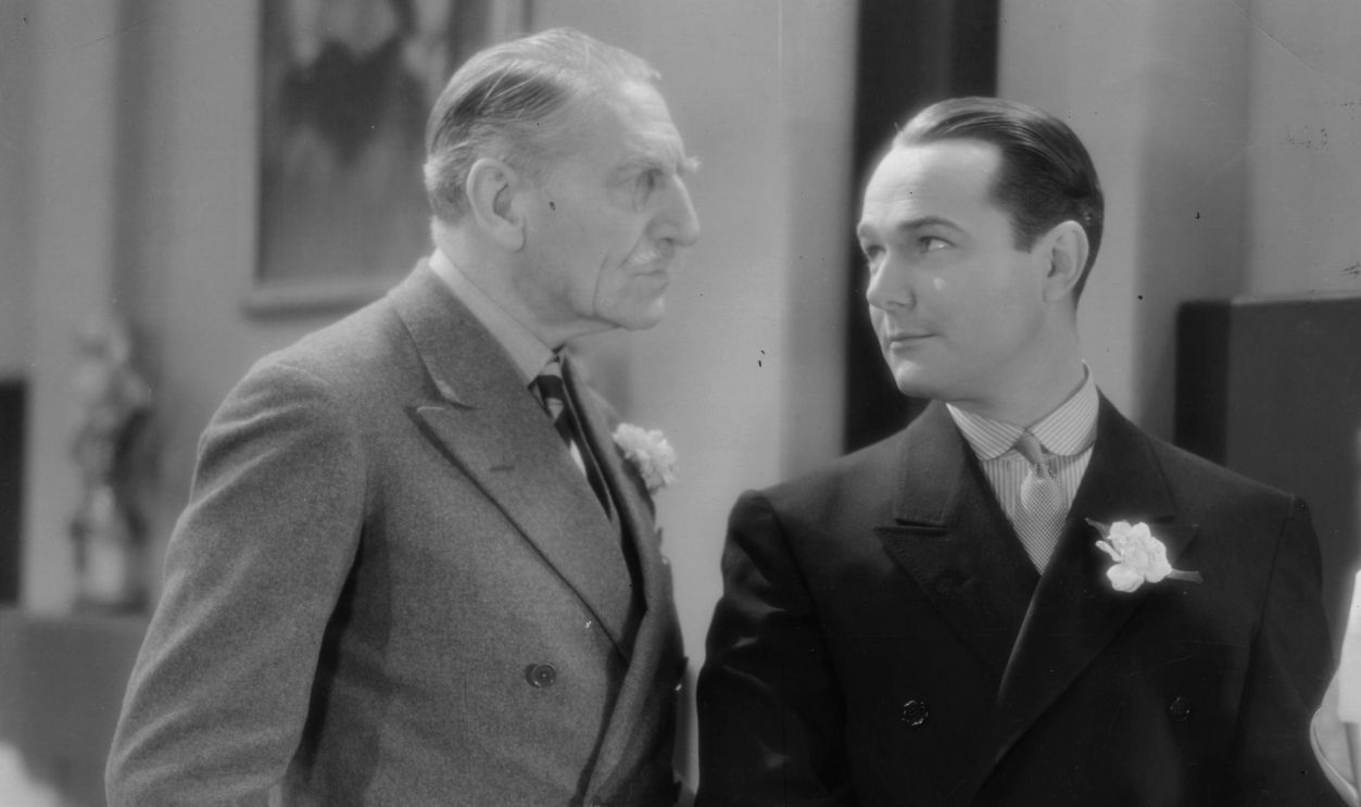 William Haines (1900 - 1973) and C Aubrey Smith (1863 - 1948) discuss a statuette in a scene from the film 