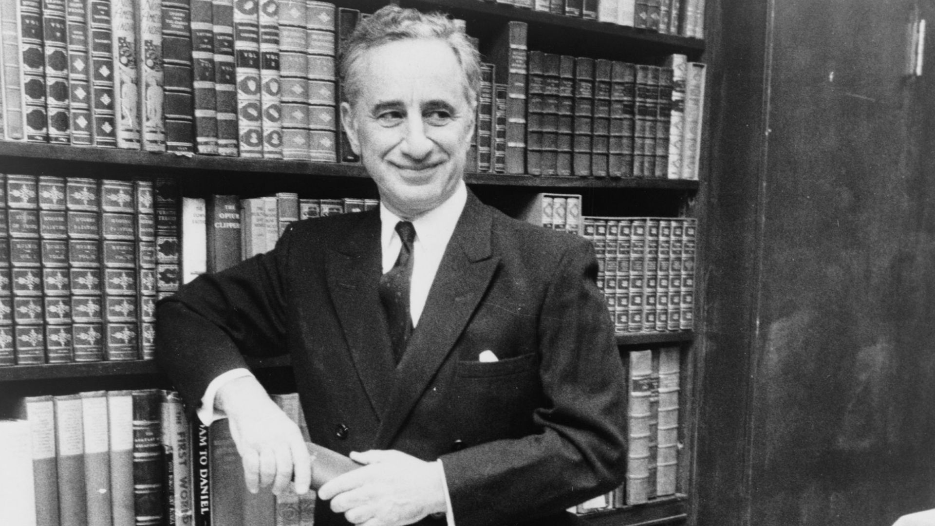 Elia Kazan, full-length portrait, standing before bookshelves at Brentano's book store / World Journal Tribune photo by James Kavallines.