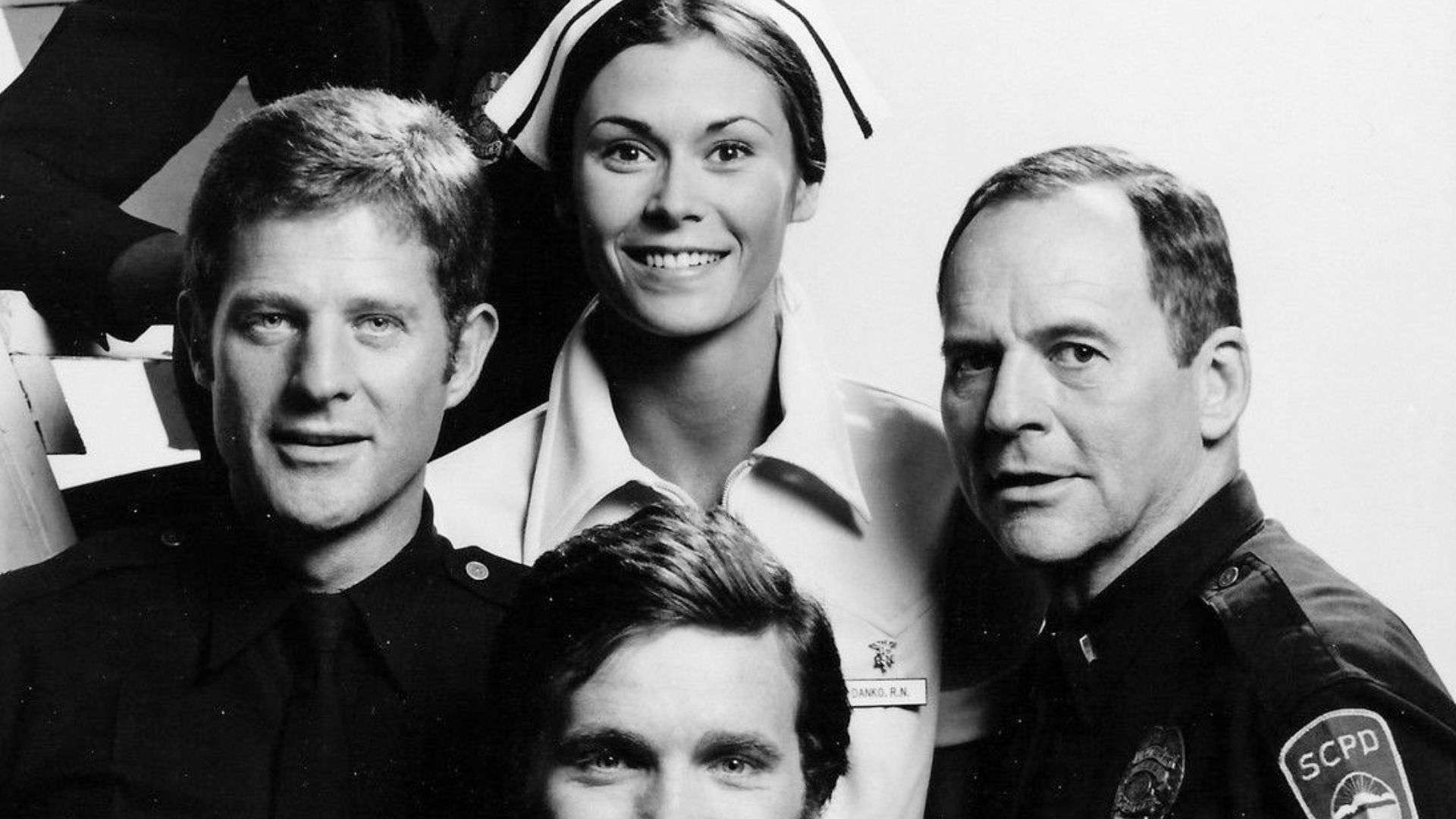 Cast photo of The Rookies from 1975.  Clockwise from top- Georg Stanford Brown (Terry Webster), Kate Jackson (Jill Danko), Gerald S. O'Loughlin (Eddie Ryker), Bruce Fairbairn (Chris Owens), and Sam Melville (Mike Danko).