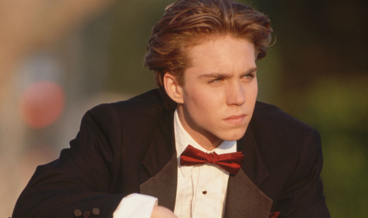 Jonathan Brandis on Dirt Bike Teen actor Jonathan Brandis poses on a dirt bike wearing a tuxedo.