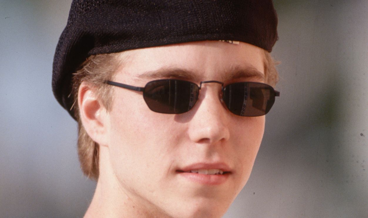 Portrait of Jonathan Brandis (Original Caption) : 1994-Los Angeles- Picture shows Johnathan Brandis posing outside. He is wearing sunglasses, barite and a open buttondown with suspenders. He is shown from the waist up. 