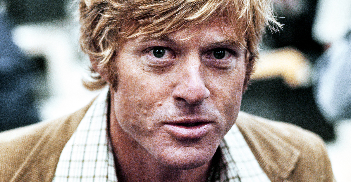 American actor Robert Redford, wearing a brown corduroy blazer over a checked shirt, in a recreation of The Washington Post's offices, on the set of 'All the President's Men,' filmed at Burbank Studios in Burbank, California, 1976. The political thriller based on the Watergate scandal, directed by Alan J Pakula, starred Redford as Bob Woodward.