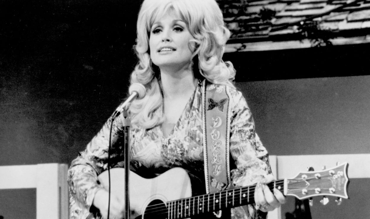  Country singer Dolly Parton performs onstage with an acoustic guitar in circa 1974. 