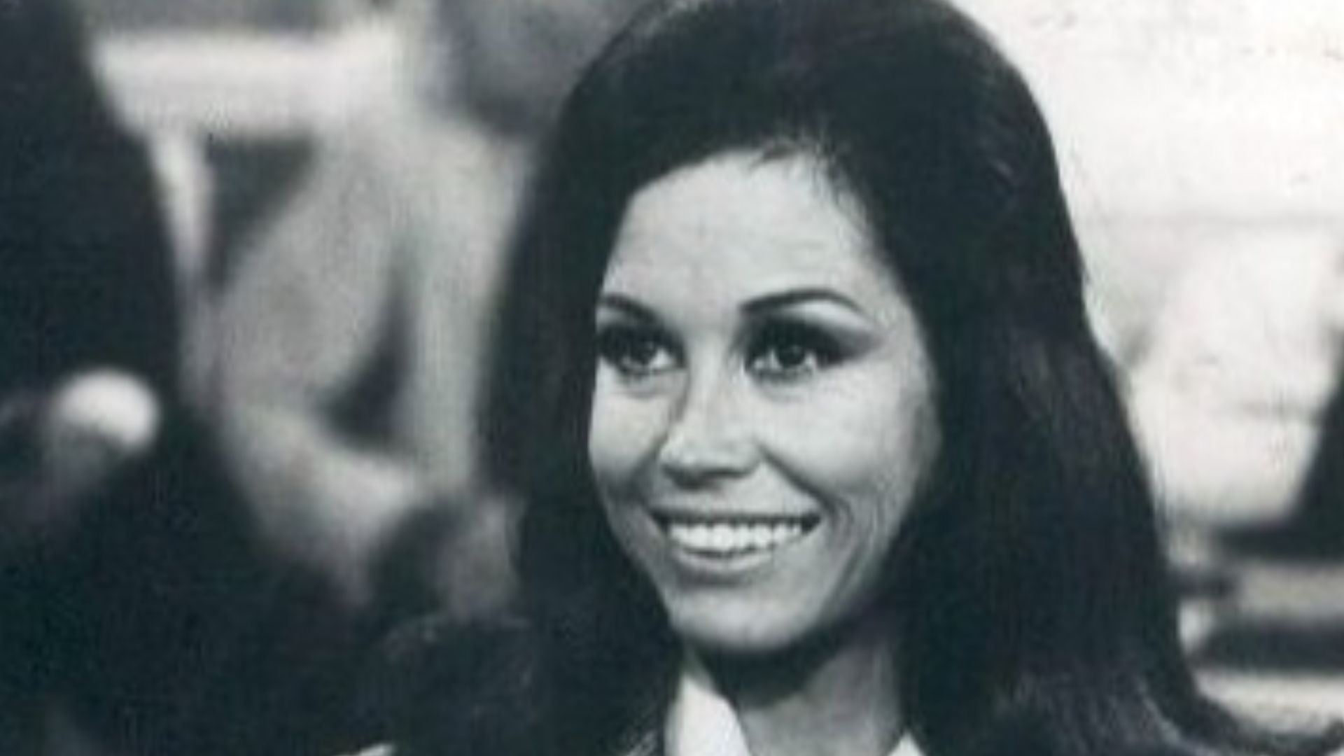 Photo scene from the television program The Mary Tyler Moore Show of Mary Tyler Moore (Mary Richards) at her desk in the WJM-TV newsroom. *Note - this came from a press release dated 1977. The scene is from a 1970 episode.*
