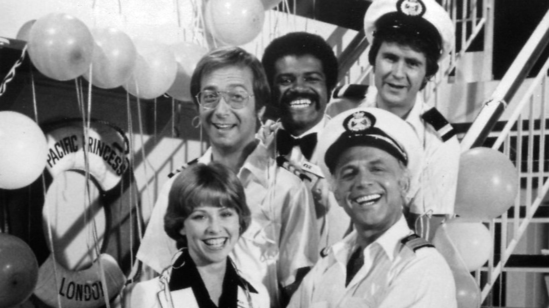 Publicity photo of cast for The Love Boat series premiere. Shown are Julie (Lauren Tewes), Captain Stubing (Gavin MacLeod), Doctor Bricker (Bernie Kopell), Isaac (Ted Lange), and Gopher (Fred Grandy).
This photo was produced prior to 1978 and has no copyright markings.