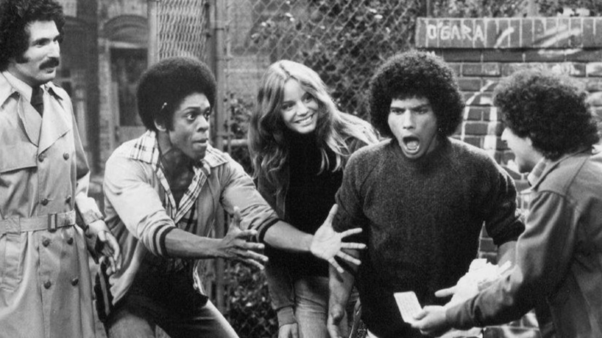 Publicity photo from the television program Welcome Back, Kotter. From left: Gabe Kaplan, Lawrence Hilton-Jacobs, Wendy Rastatter, Robert Hegyes, and Ron Palillo.  The Sweathogs are celebrating a winning New York State lottery ticket while Mr. Kotter look