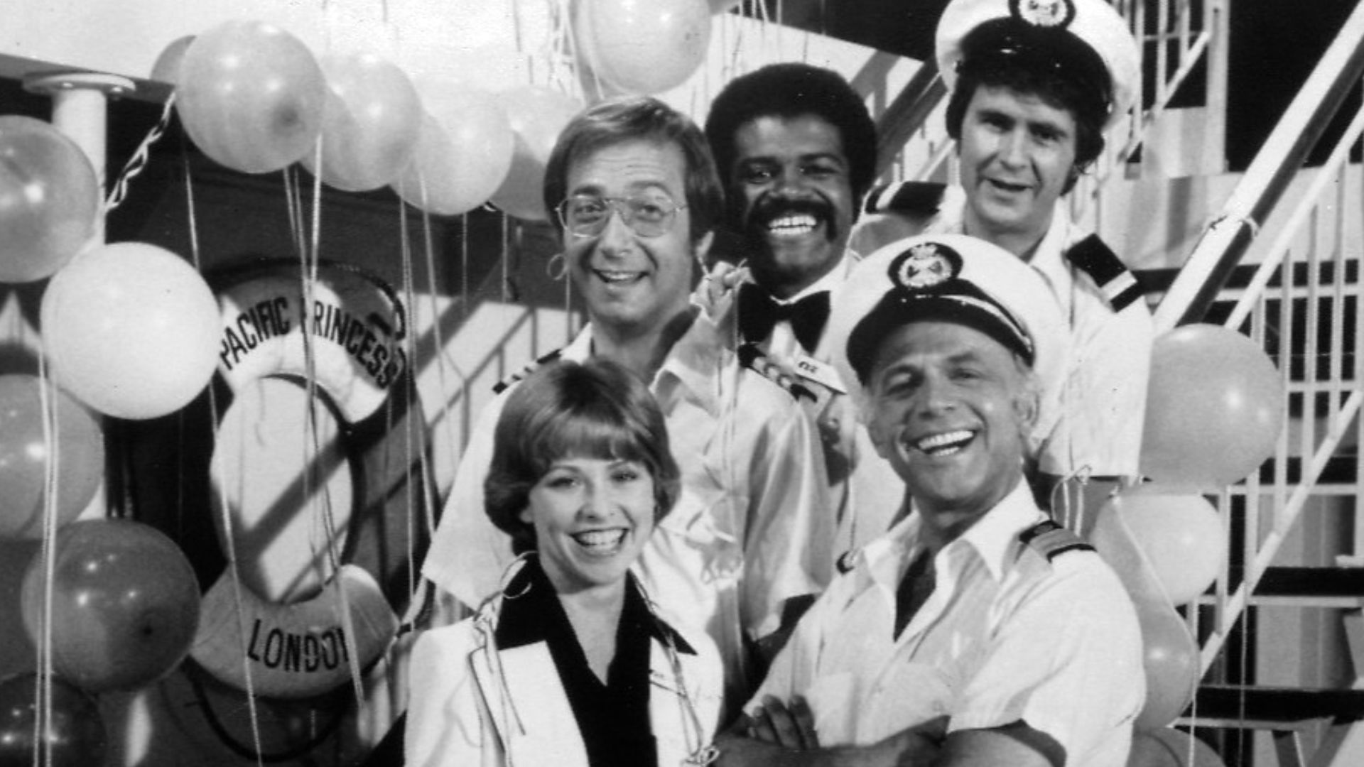 Publicity photo of cast for The Love Boat series premiere. Shown are Julie (Lauren Tewes), Captain Stubing (Gavin MacLeod), Doctor Bricker (Bernie Kopell), Isaac (Ted Lange), and Gopher (Fred Grandy).
This photo was produced prior to 1978 and has no copyr