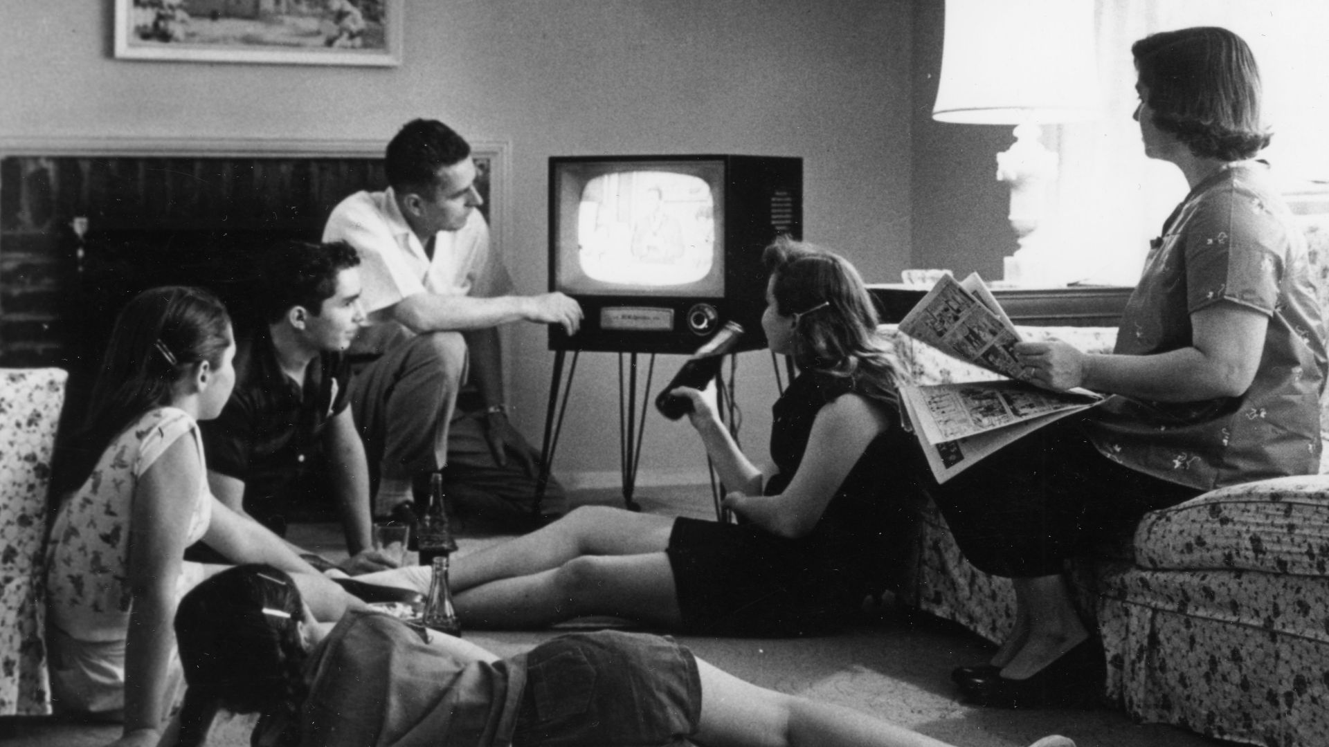 Family watching television in their home, c. 1958