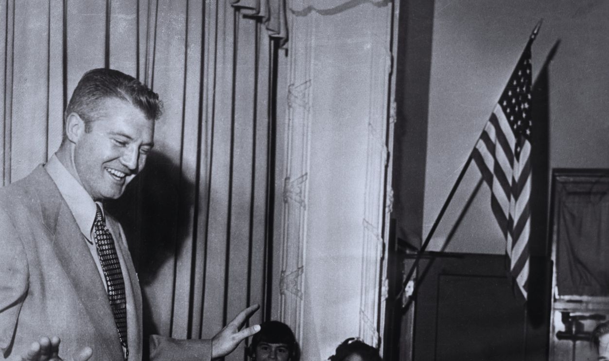 Gettyimages - 3227394, O Superman 1955: American actor George Reeves, from the television series 'Superman,' smiles and holds his hands out, as a group of children applaud him at a school classroom appearance.