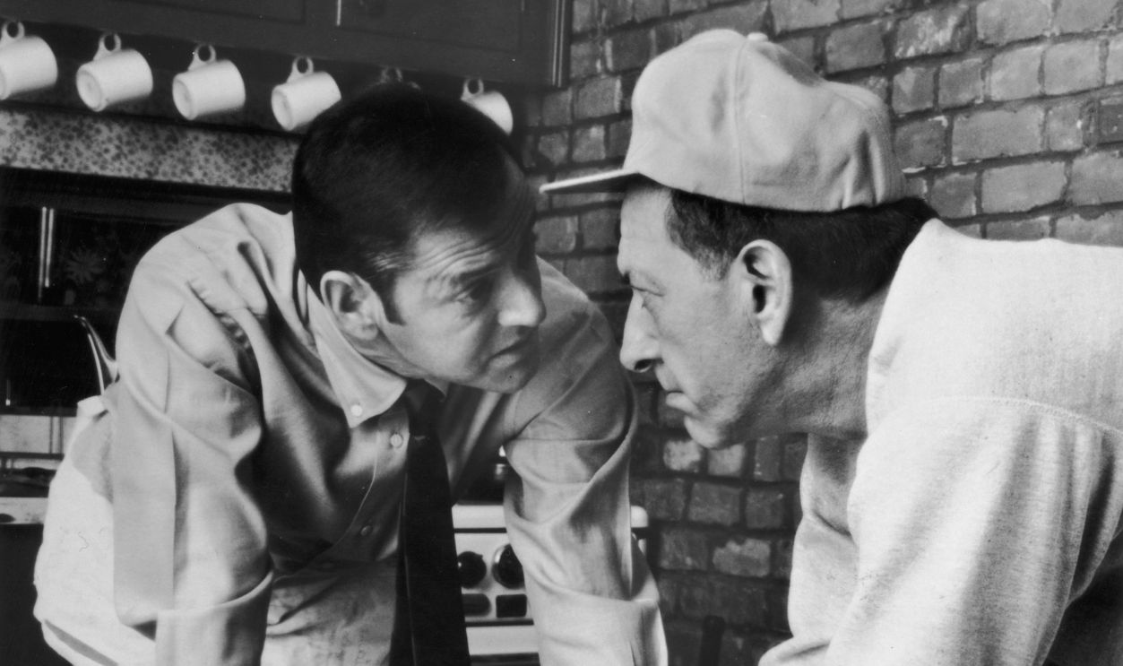 Getty Images - 3206568 - American actors Tony Randall and Jack Klugman face off while leaning over a table covered with litter in a still from the television comedy series, 'The Odd Couple'.