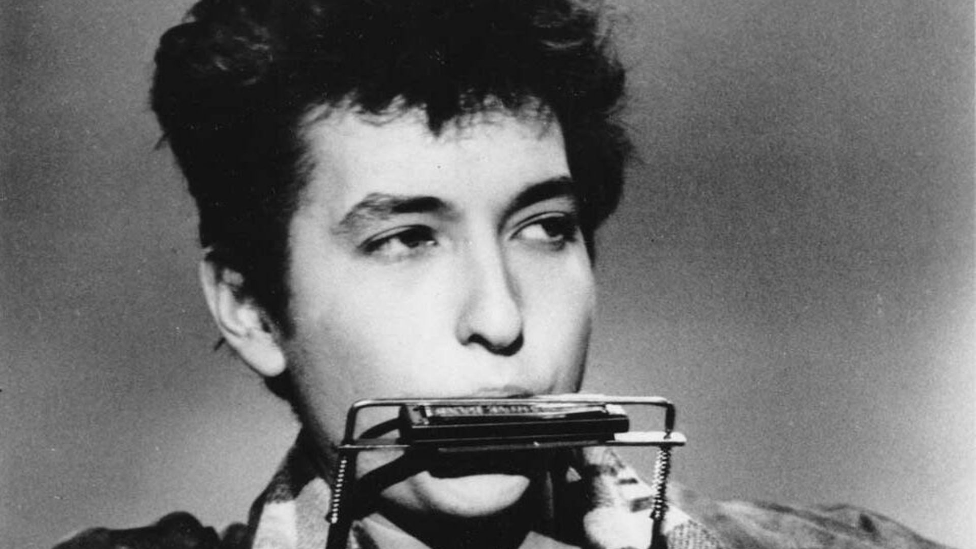 Bob Dylan plays harmonica and guitar in March 1963.