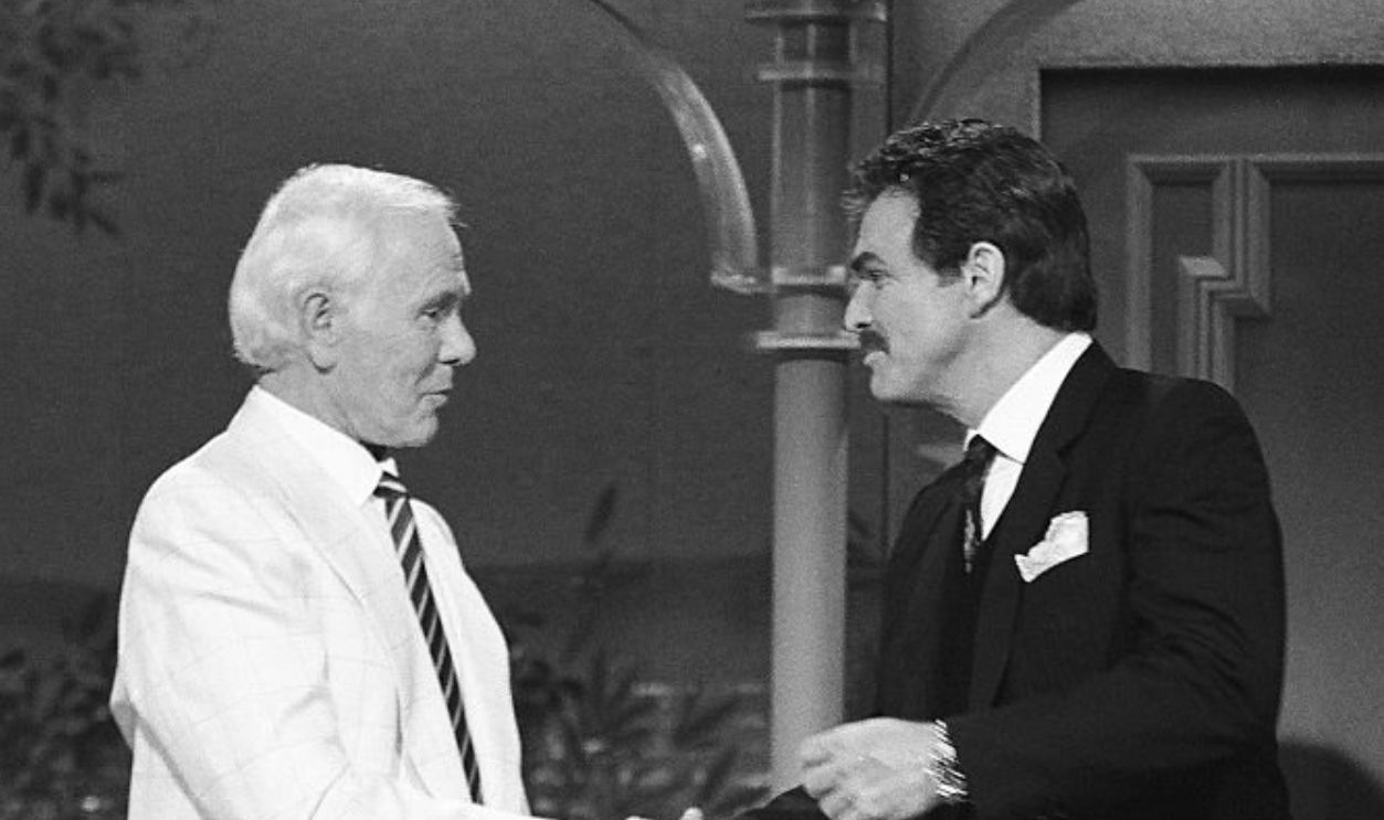 Getty Images - 487792400 - THE TONIGHT SHOW STARRING JOHNNY CARSON -- Pictured: (l-r) Host Johnny Carson greets actor Burt Reynolds on August 21, 1991.