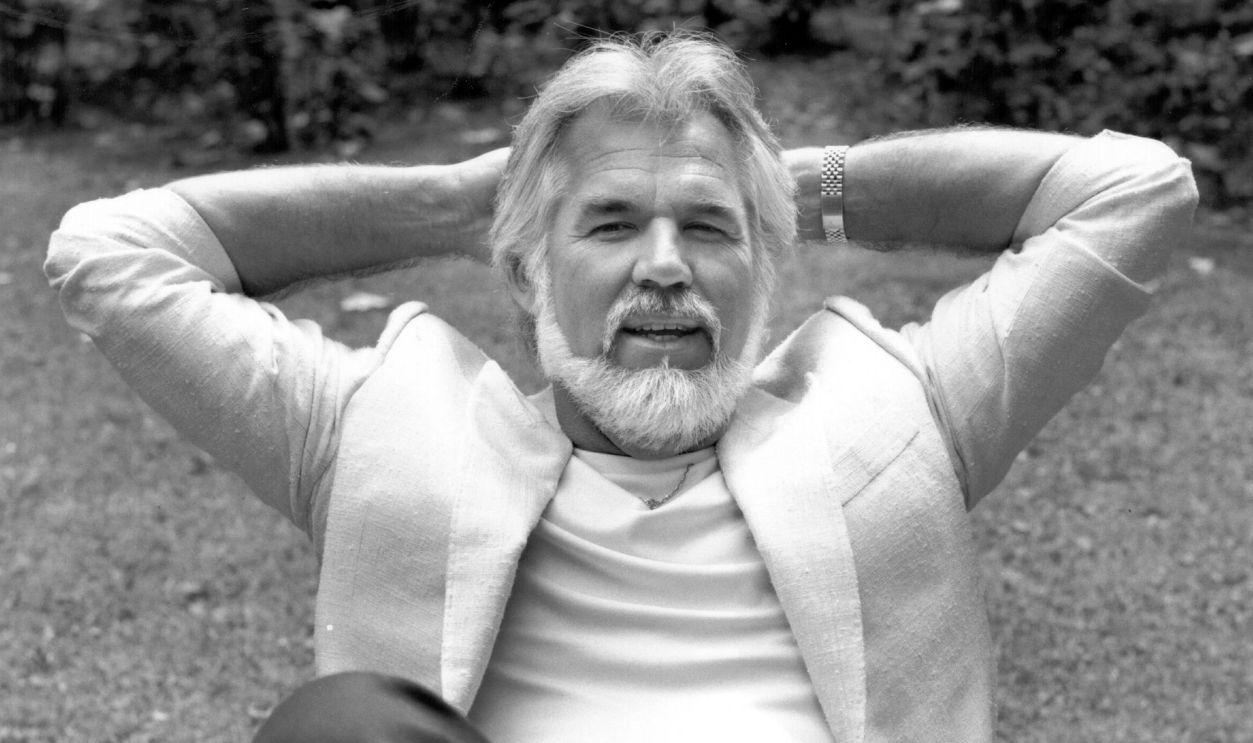 American country pop singer Kenny Rogers relaxes in a garden