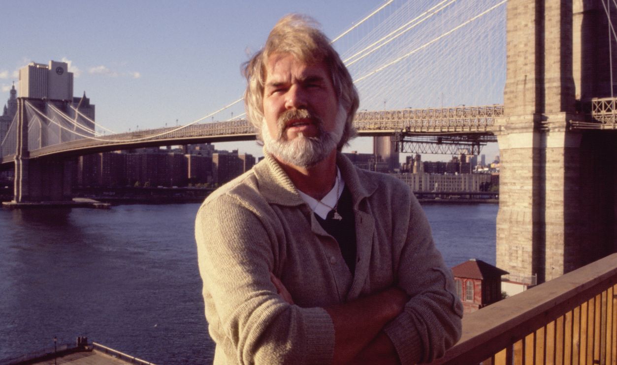 Portrait of American musician Kenny Rogers (1938 - 2020) during a rooftop reception in Brooklyn Heights, New York, New York, September 26, 1980. The reception was to celebrate the opening of the Ken Kragen & Company music management offices. Visible in the background is the Brooklyn Bridge.