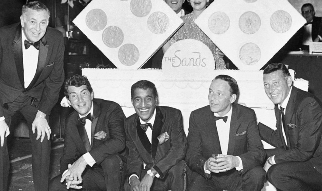 Dean Martin, Sammy Davis Jr., Danny Thomas, Lucille Ball, Frank Sinatra stand around a cake for the eleventh anniversary of the Sands Hotel in Las Vegas.