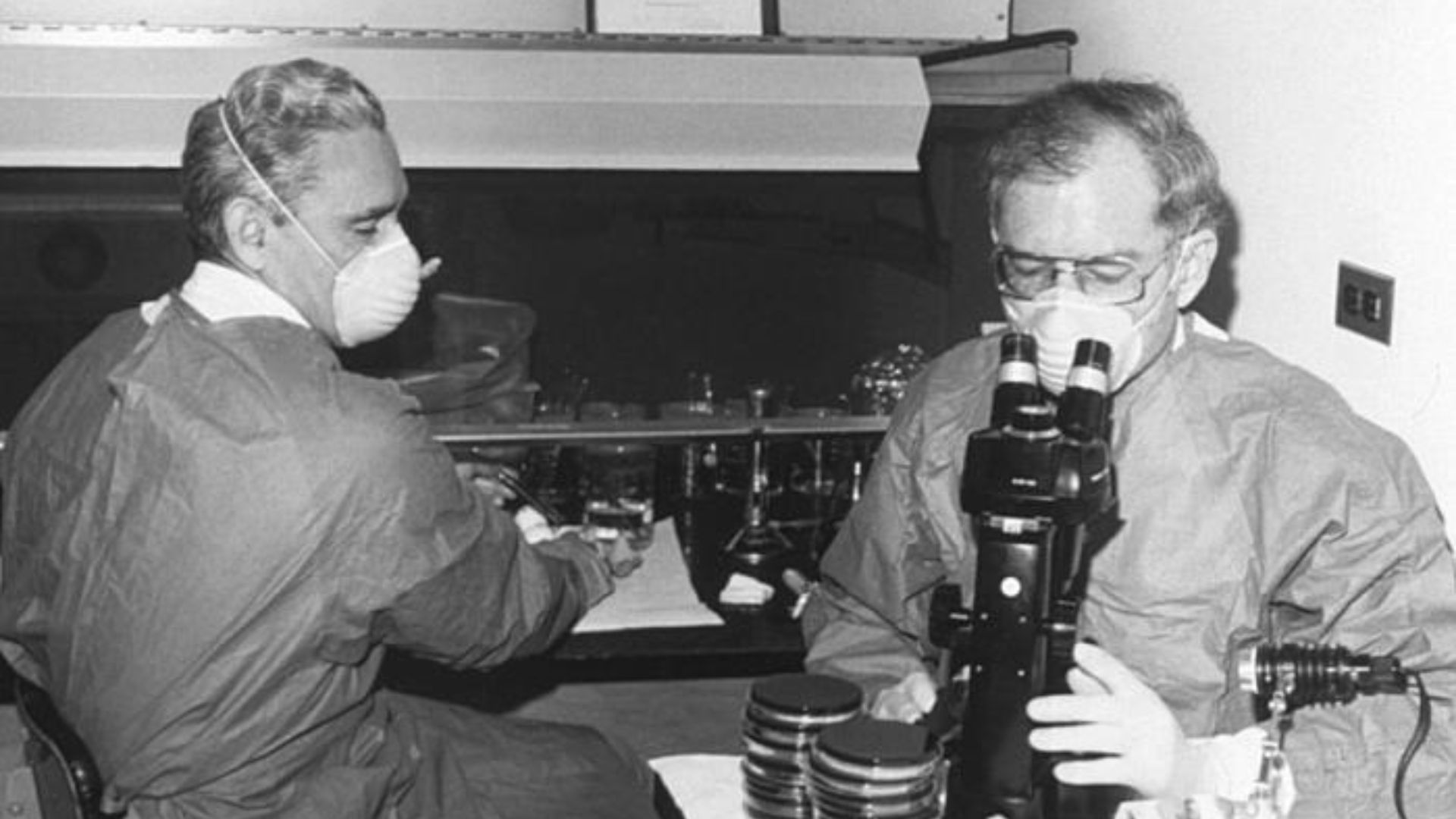 This historic photograph depicted Centers for Disease Control (CDC) laboratorian George Gorman at left, along side Dr. Jim Feeley, while they were examining culture plates, i.e., Petri dishes, upon which the first environmental isolates of Legionella pneu