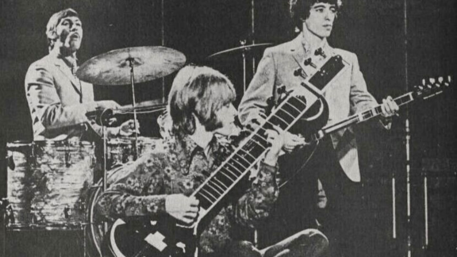 Brian Jones playing sitar, with Charlie Watts and Bill Wyman in the background. Although published in Hit Parader magazine's Jan 1968 issue, the photo itself was taken around 1966.