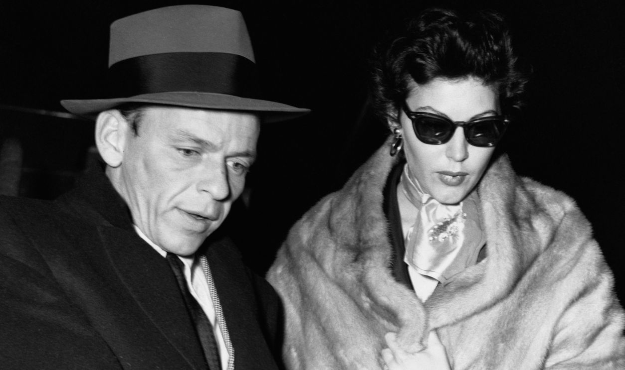 Getty Images - 514957624 - Arm-in-arm, Frank Sinatra and his wife, Ava Gardner, arrive in Rome by plane after spending the Christmas holidays and Ava's birthday together in Madrid. Sinatra flew to Europe from Hollywood to be with his wife who had previously announced that she would divorce the singer.