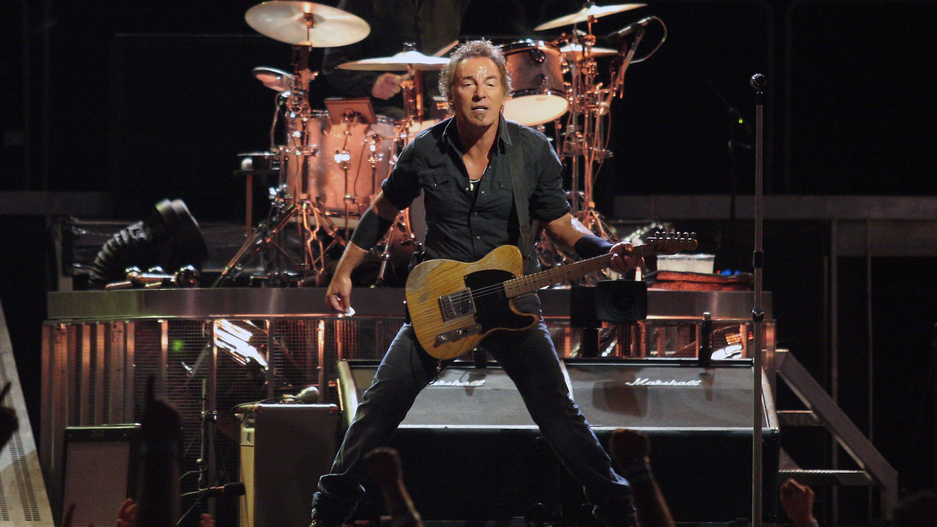 Bruce Springsteen (with Max Weinberg in background on drums) in concert
