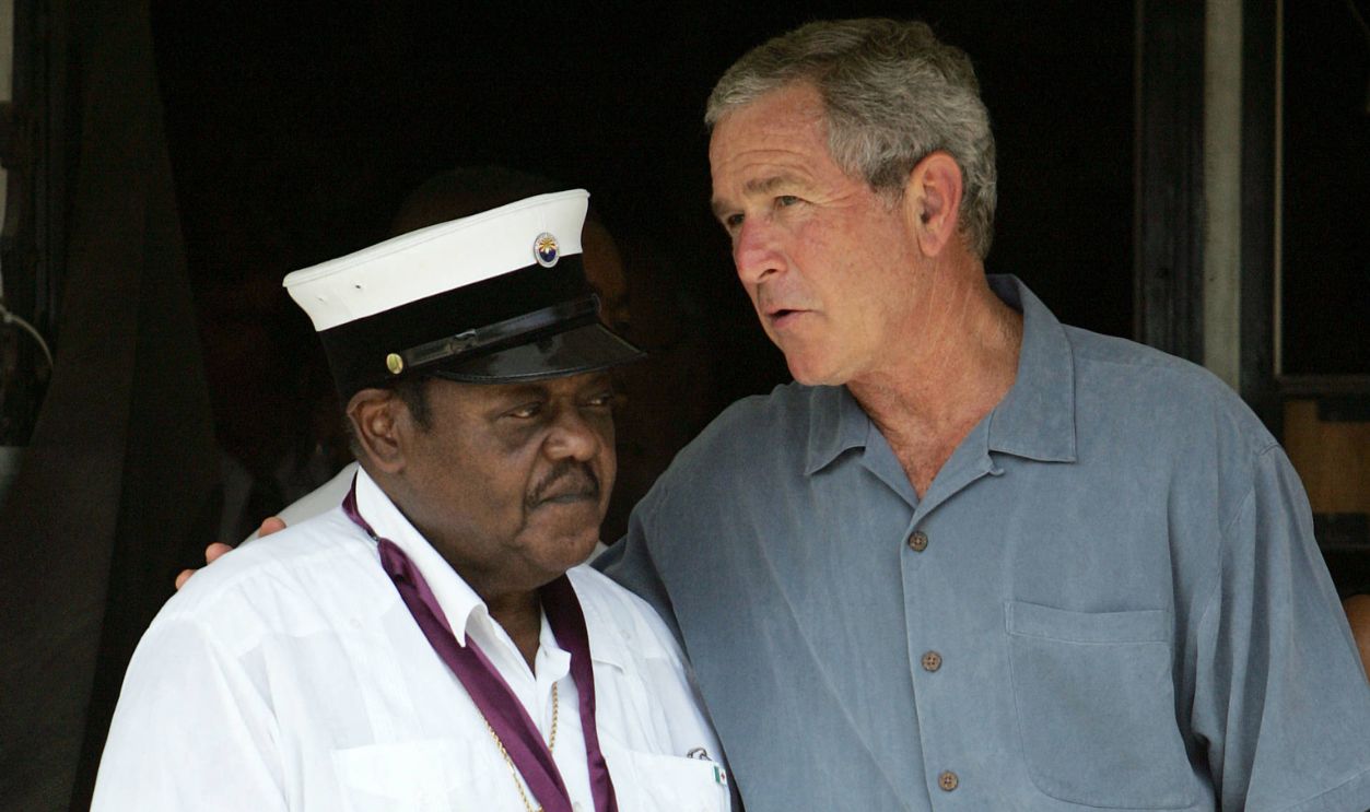 US President George W. Bush (R) speaks with US rock & roll legend Fats Domino (L) 29 August 2006 in the Lower Ninth Ward of New Orleans, Louisiana, on the first anniversary of Hurricane Katrina. Bush spoke about replacing the Domino's Presidential Medal for the Arts, which was lost in flooding at the singer's Lower Ninth Ward residence during the disater.