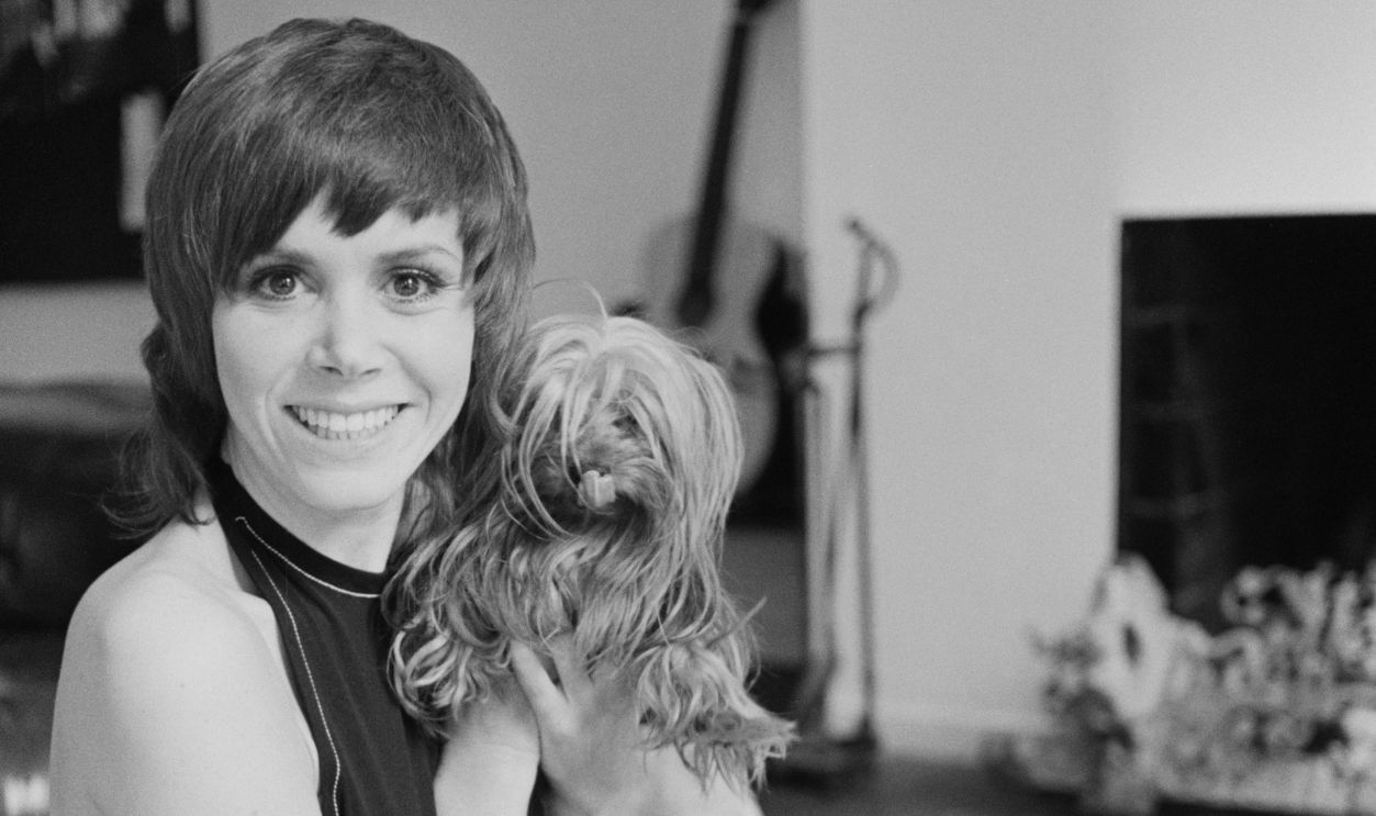 English actress Judy Carne (1939 - 2015) with a small dog, UK, 15th March 1970. 