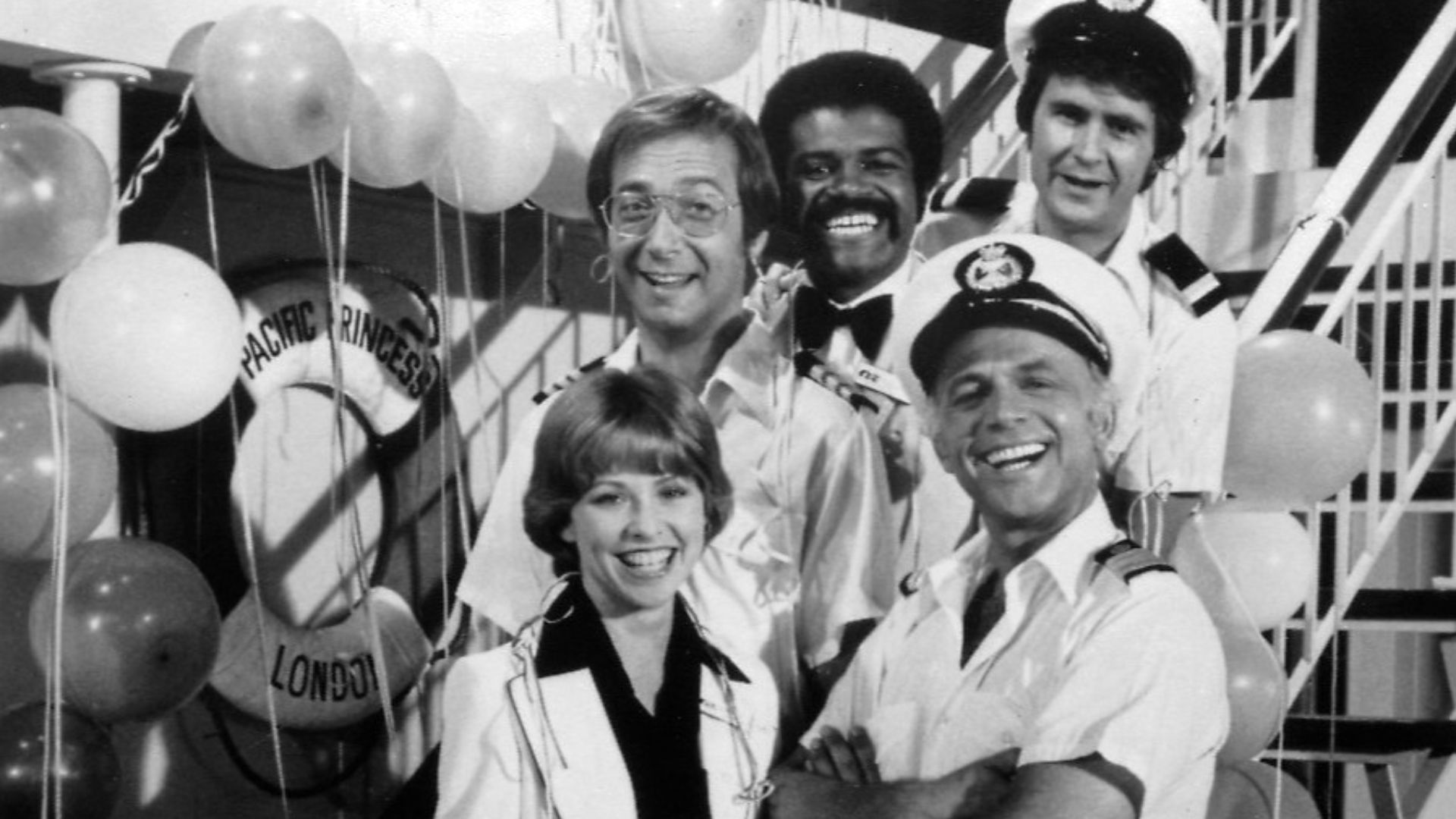 Publicity photo of cast for The Love Boat series premiere. Shown are Julie (Lauren Tewes), Captain Stubing (Gavin MacLeod), Doctor Bricker (Bernie Kopell), Isaac (Ted Lange), and Gopher (Fred Grandy).
This photo was produced prior to 1978 and has no copyr