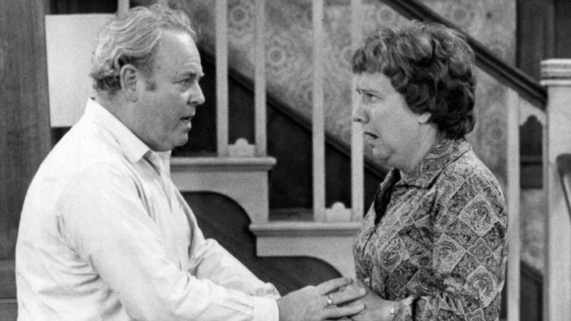 Photo of Carroll O'Connor and Jean Stapleton as Archie and Edith Bunker from the television program All In the Family.  When Archie comes home in a great mood with gifts for everyone in the family, happiness turns to shock and anger when it's discovered h
