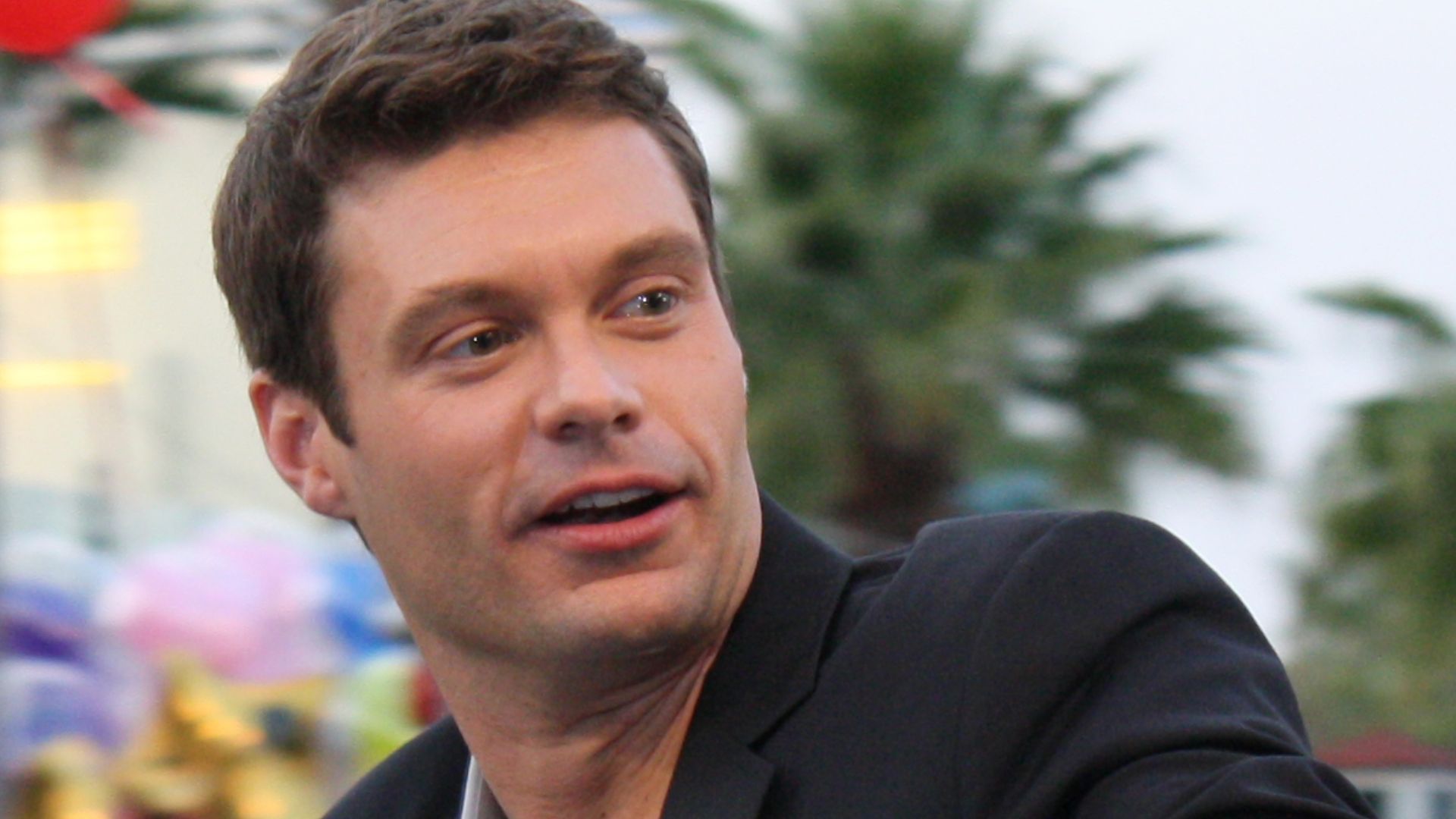 Host of American Idol, and numerous other radio and television programs, Ryan Seacrest. Seacrest is photographed in a parade at Walt Disney World in Florida, at an event related to the American Idol Experience stage attraction.