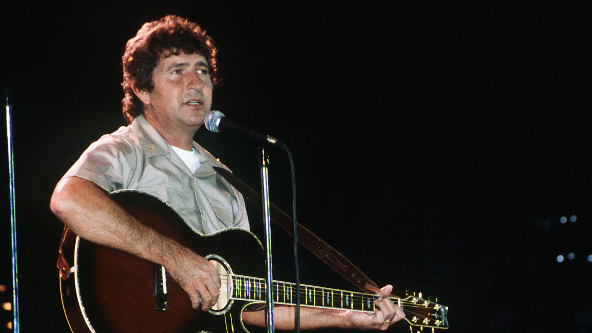 Country western music singer Mac Davis performs in a United Service Organizations (USO) show in the Pensacola Civic Center during the celebration of the 75th anniversary of naval aviation. VIRIN DN-ST-87-03194