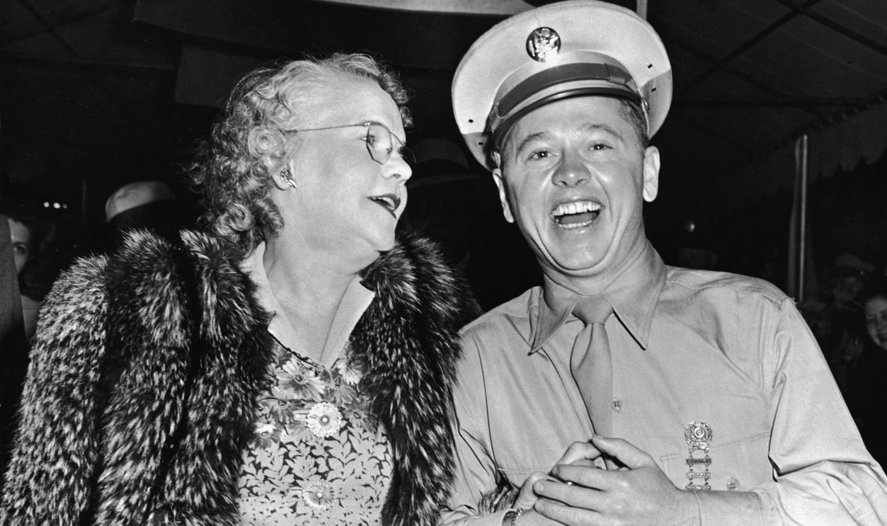 American actor Mickey Rooney, in army uniform, holding hands with his mother, August 15, 1944.