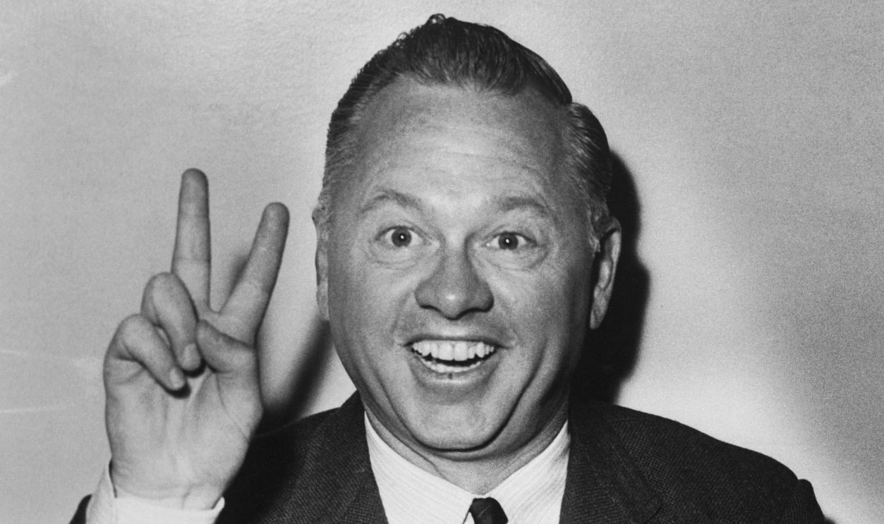 It's all smiles and two fingers for Mickey Rooney, but his smiling two fingered gesture is to show that he has double troubles with ex-wives. Two of his ex-wives are suing him for support payments. He claimed in Santa Monica court that he earned $75,000 this year, but he owes $175,000.