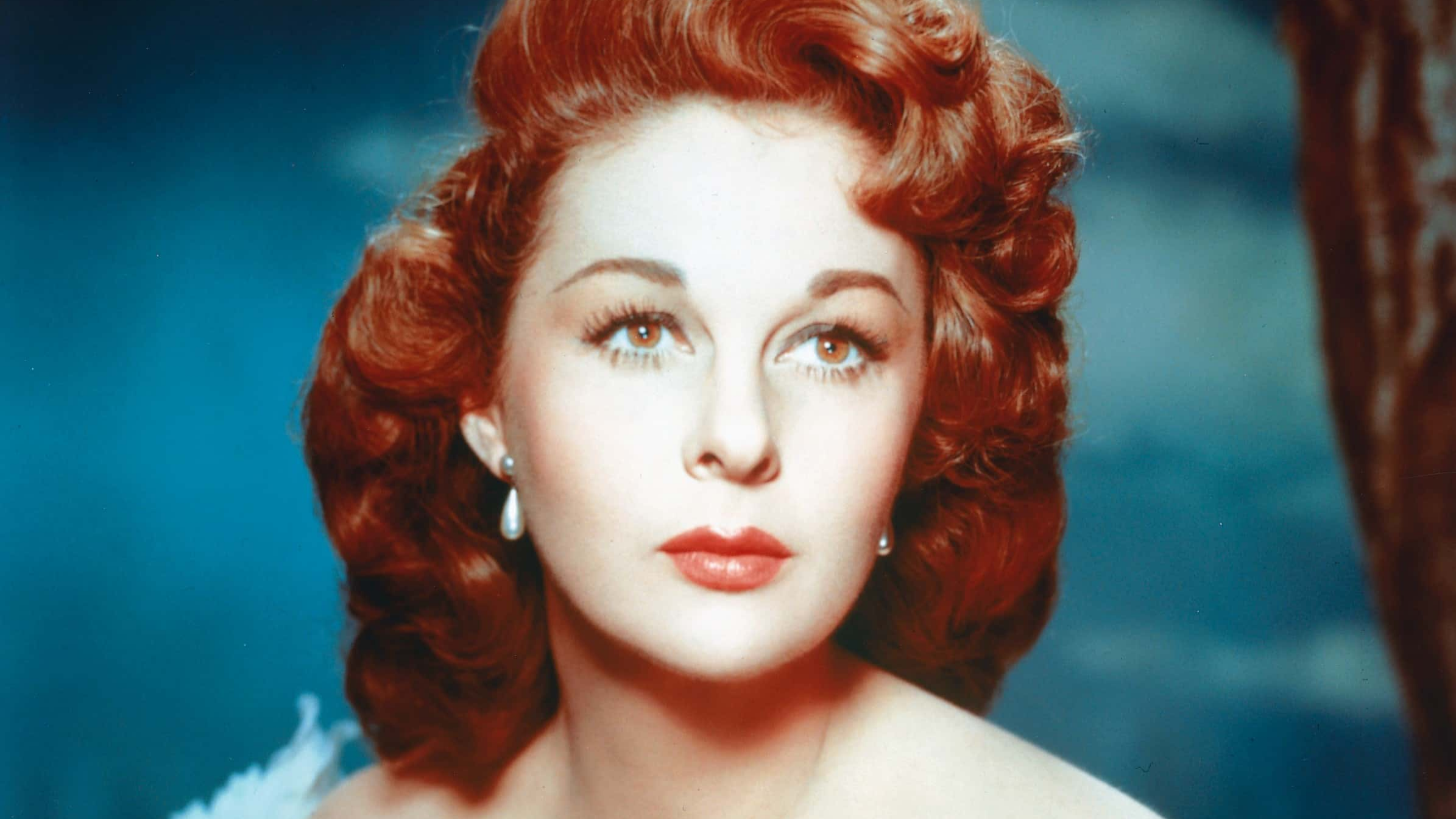 American actress Susan Hayward (1918 - 1975) contrasts her red hair with a blue dress, circa 1950