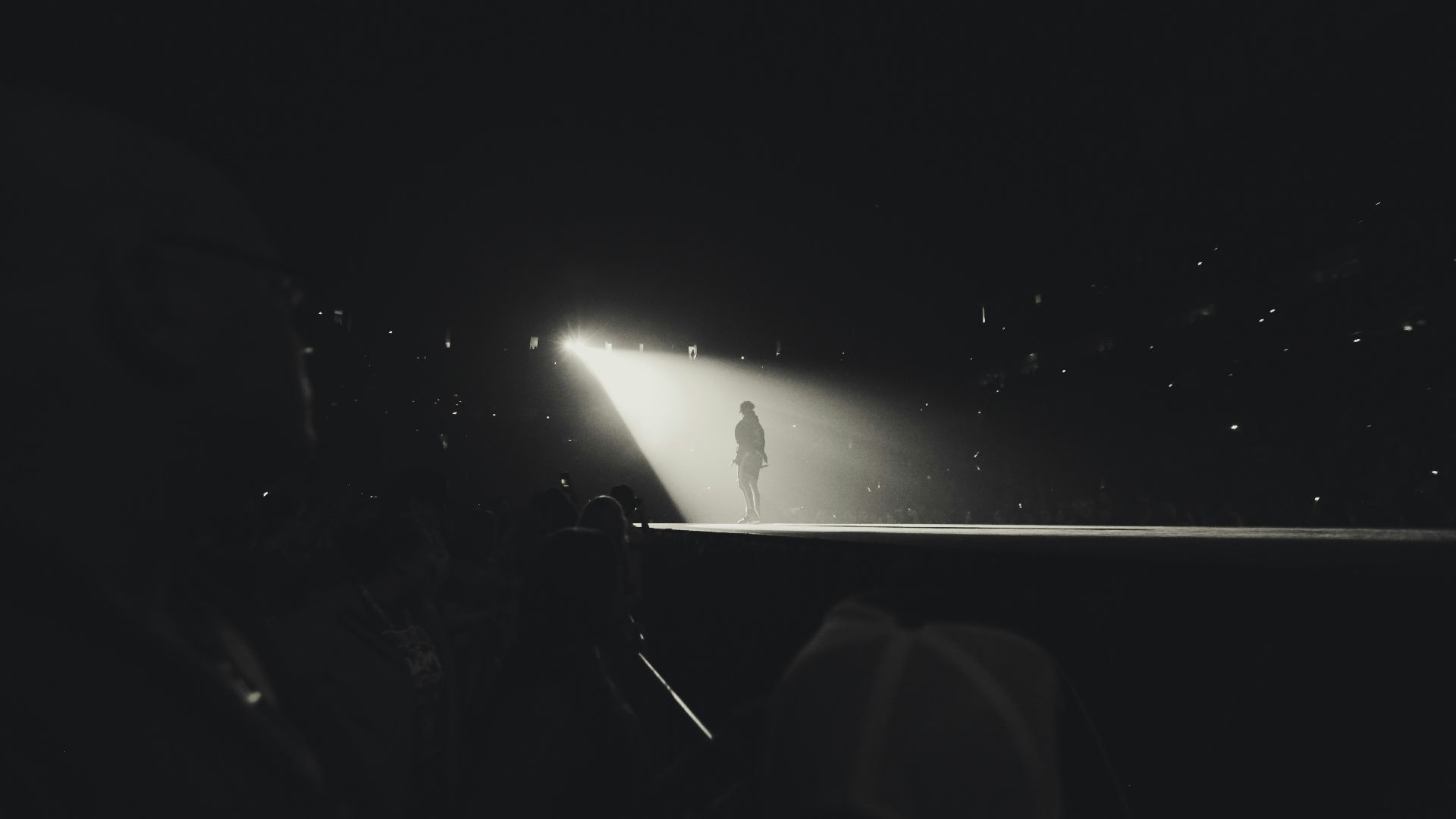 a black and white photo of a person standing in the dark