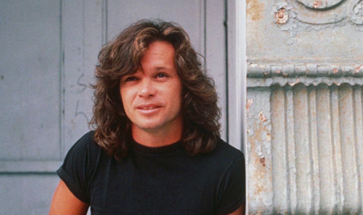 John Cougar Mellencamp Leaning on Building