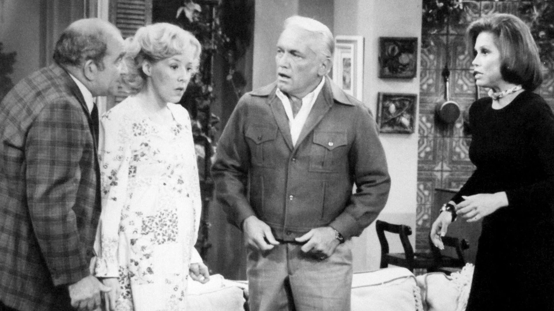 Photo from The Mary Tyler Moore Show.  Mary gives a dinner party that winds up as a birthday party when Georgette Baxter goes into labor during the dinner.  From left: Ed Asner (Lou Grant), Georgia Engel (Georgette Baxter), Ted Knight (Ted Baxter) and Mar