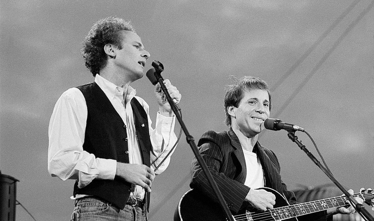 (Original Caption) 9/19/1980-New York, New York- Art Garfunkel (l) and Paul Simon perform for more than 500,000 fans in Central Park 9/19. Police said the crowd was the largest to ever gather in the park. The concert marked the first ever time Simon and Garfunkel have appeared together in concert in 11 years. Garfunkel is shown singing while Simon is smiling into the audience.