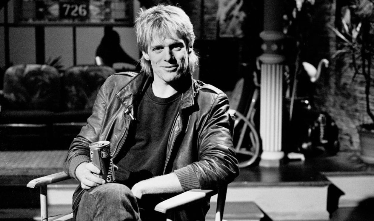 View of Canadian Rock musician Bryan Adams as he sits in a director's chair during an interview at MTV Studios, New York, New York, April 1, 1982.
