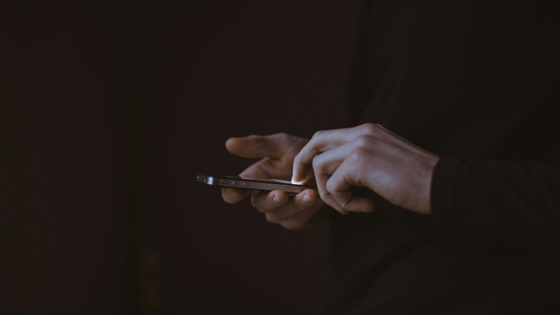 silhouette photo of person holding smartphone