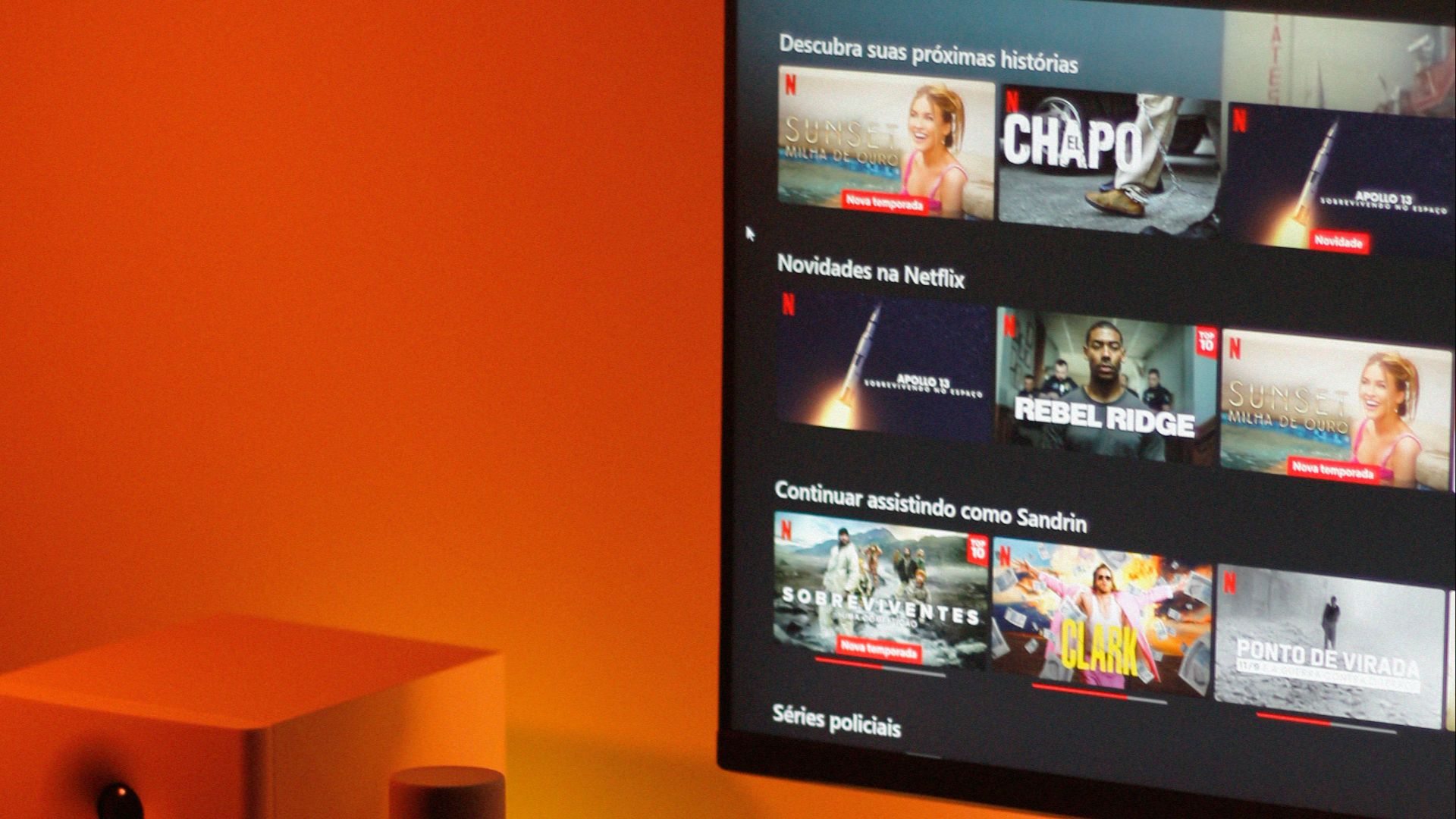 Warmly lit home office setup with a computer monitor displaying a streaming service interface.