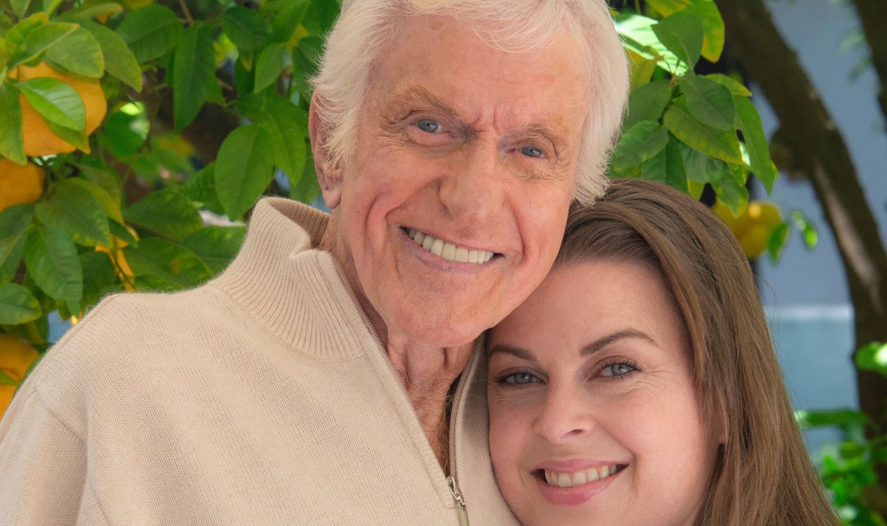 Actor Dick Van Dyke, wearing a beige zip-front sweater and holding a lemon, and his wife Arlene Silver, wearing a blue sweater are photographed at home under their lemon tree in front of a blue wall for a magazine story on April 21, 2016 in Malibu, California.