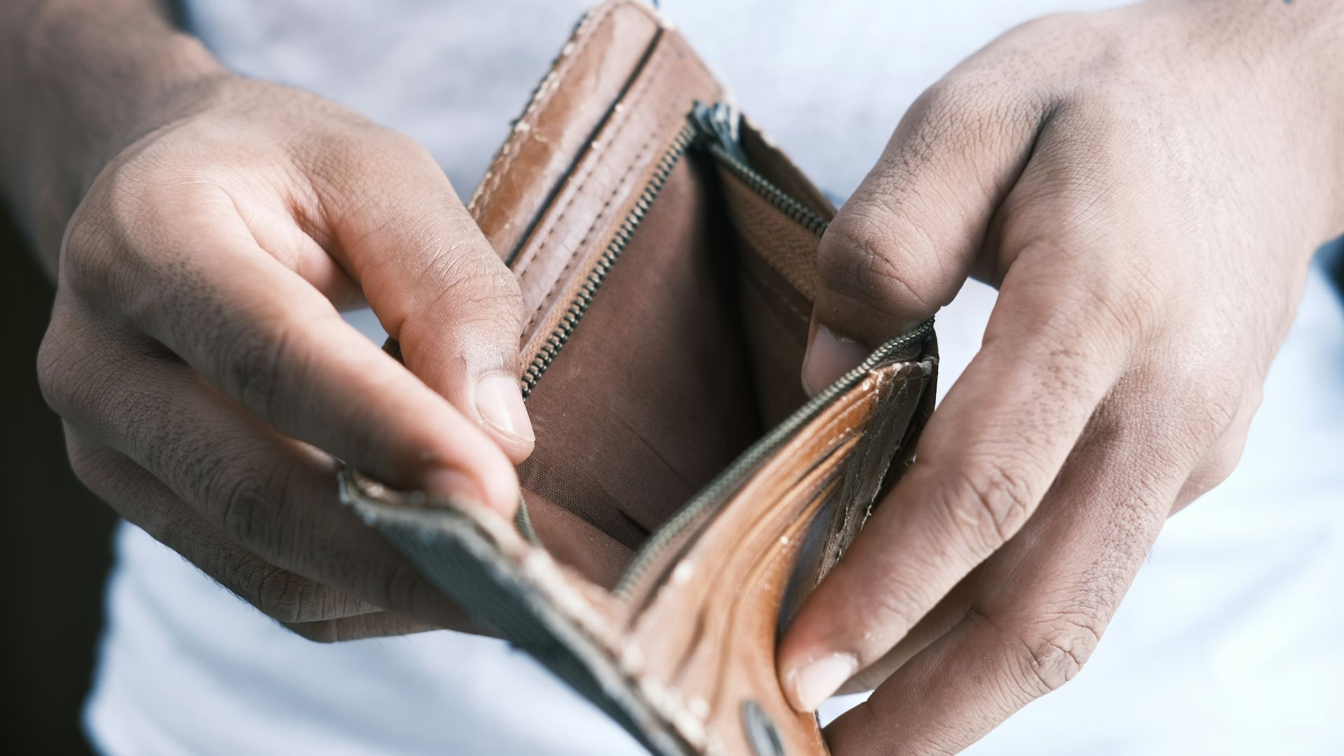 person holding brown leather bifold wallet