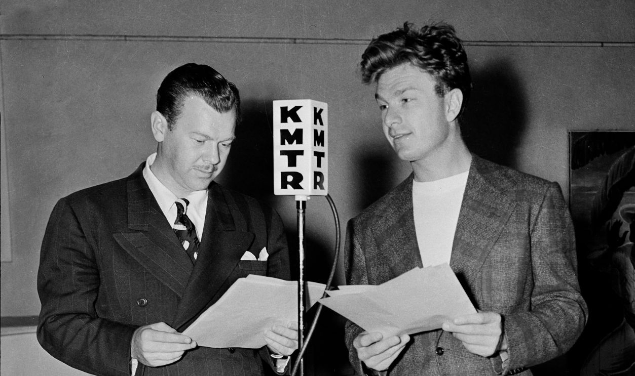 Eddie Albert reads his script during a KMTR Radio Show in Los Angeles, California.