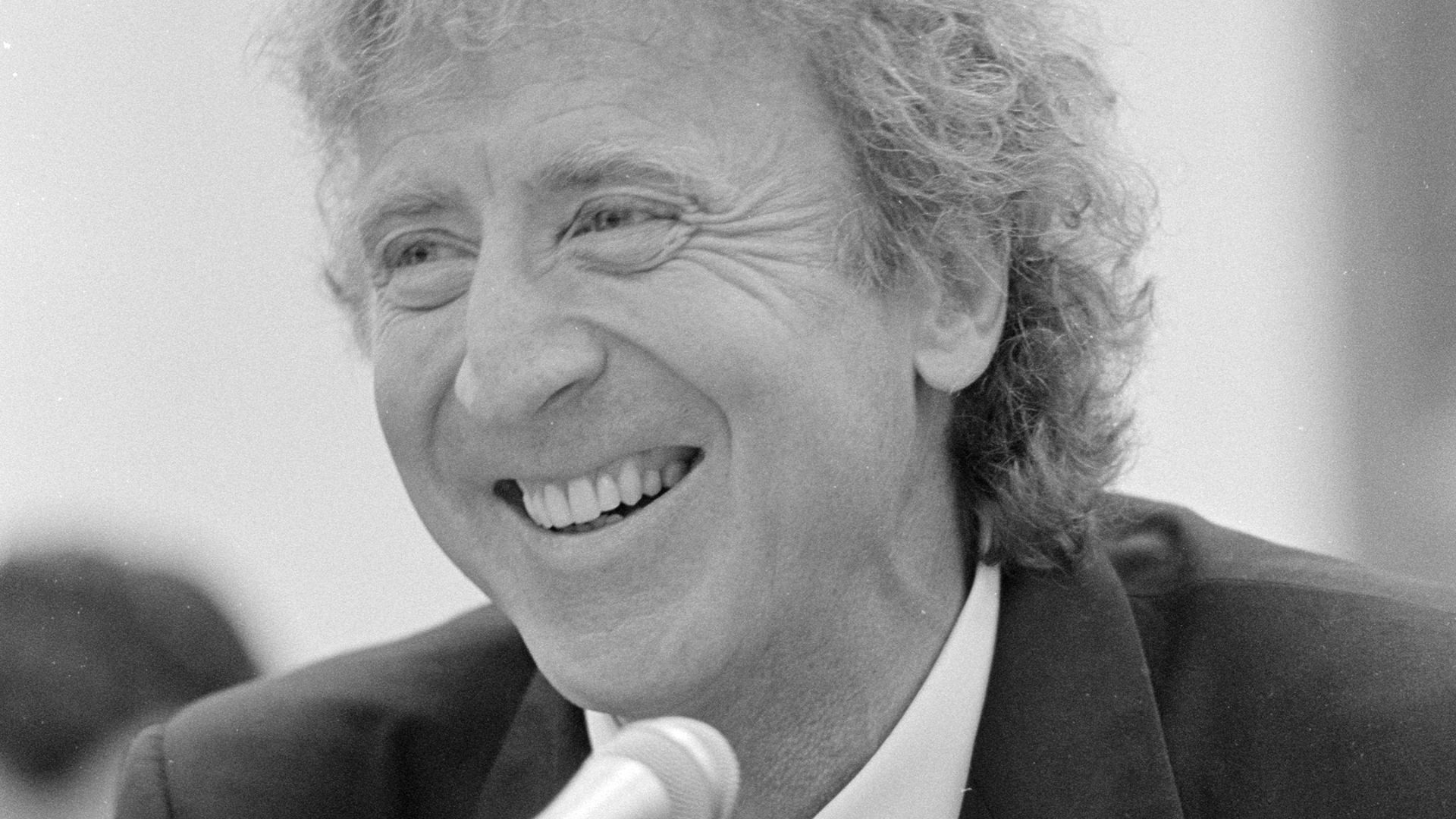 Gene Wilder, head-and-shoulders portrait, facing front, speaking in front of a United States House of Representatives Appropriations subcommittee on ovarian cancer research