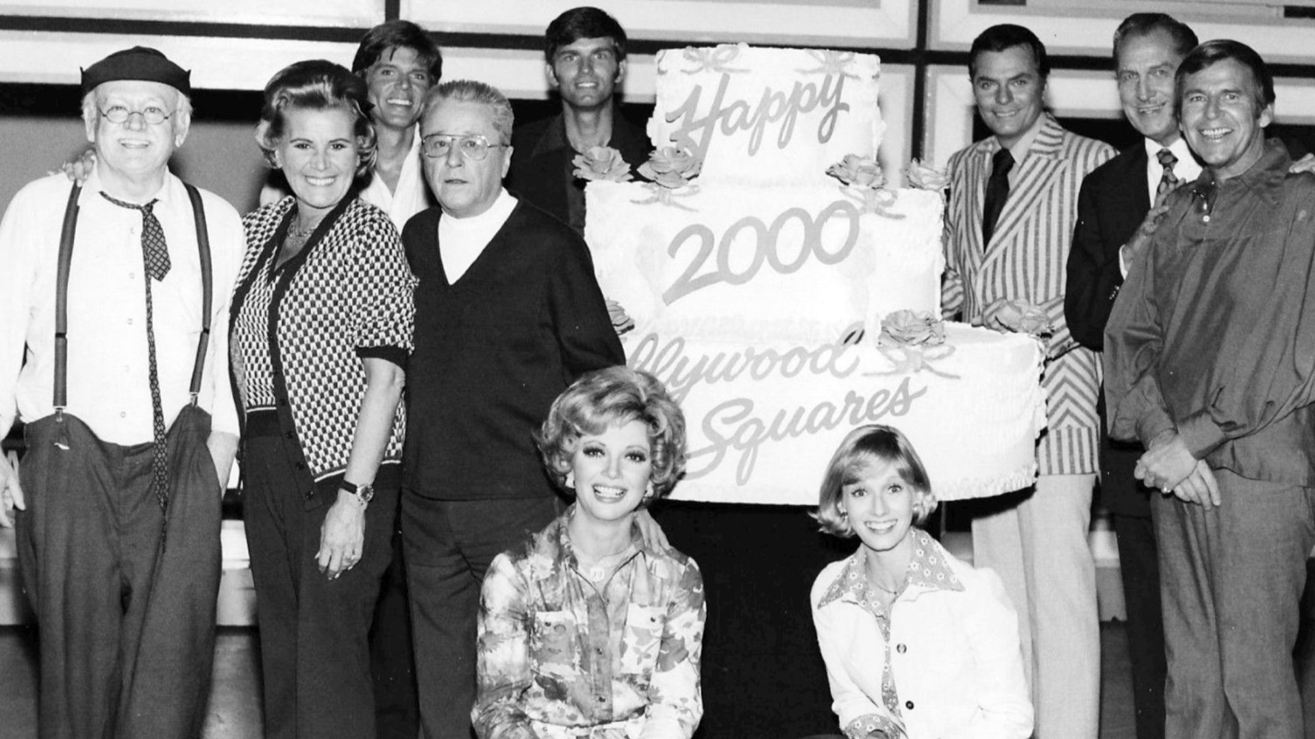 Photo from the television game show Hollywood Squares.  This was to celebrate the 2,000th show in 1974.  Pictured are Cliff Arquette as Charley Weaver, Rose Marie, John Davidson, George Gobel, Kent McCord, Peter Marshall, Vincent Price, Paul Lynde, Sandy 
