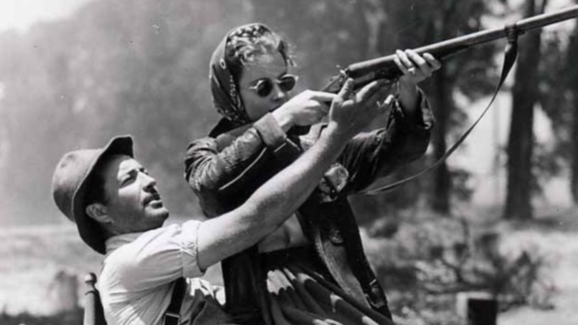 Robert Taylor showing Susan Peters how to shoot a rifle on the set of Song of Russia