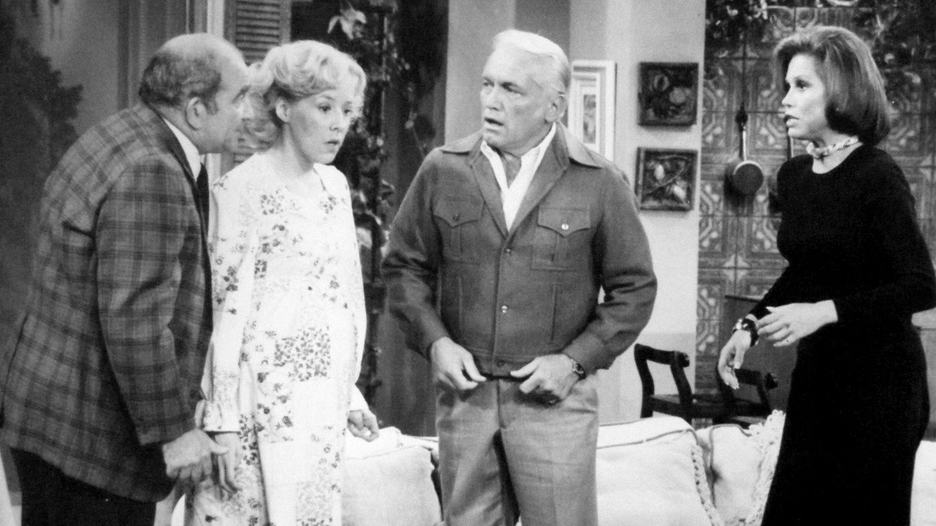 Photo from The Mary Tyler Moore Show.  Mary gives a dinner party that winds up as a birthday party when Georgette Baxter goes into labor during the dinner.  From left: Ed Asner (Lou Grant), Georgia Engel (Georgette Baxter), Ted Knight (Ted Baxter) and Mar